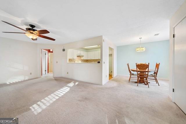 unfurnished living room with ceiling fan and light colored carpet