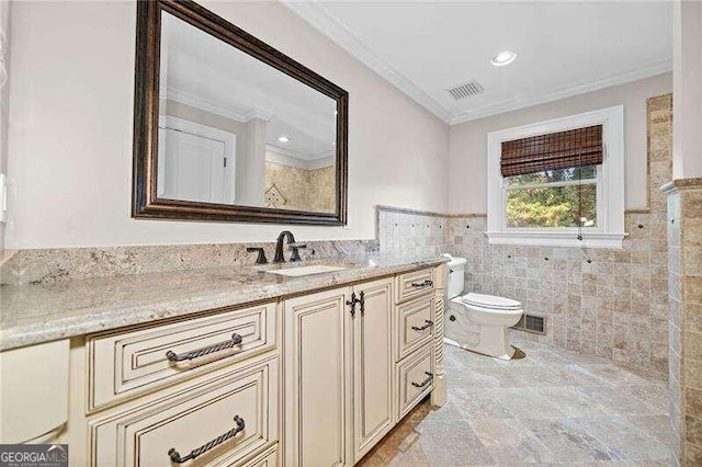 bathroom with toilet, vanity, tile walls, and ornamental molding