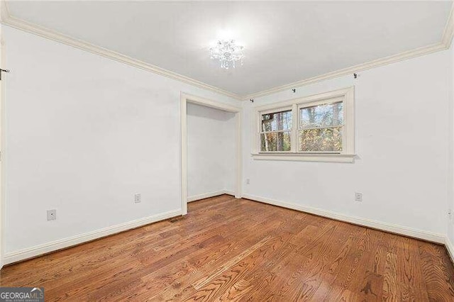 spare room featuring light wood-type flooring and ornamental molding