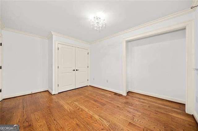 unfurnished bedroom featuring light hardwood / wood-style flooring, a closet, and crown molding