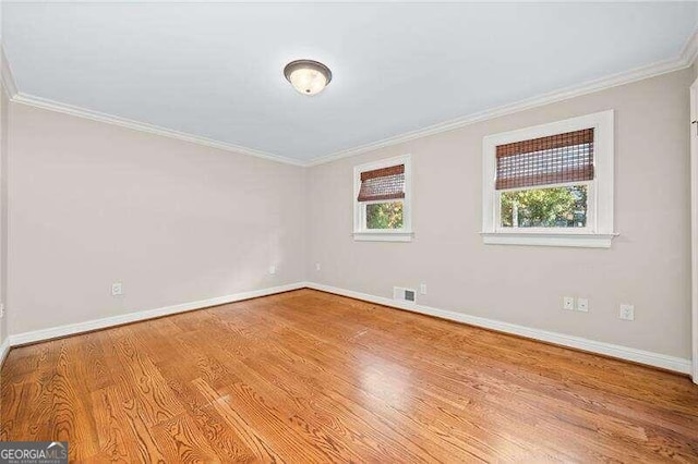 empty room with light wood-type flooring and ornamental molding