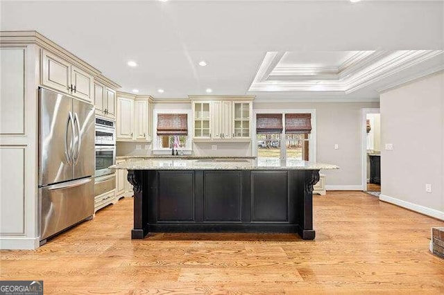 kitchen featuring light stone counters, light hardwood / wood-style flooring, a center island, and stainless steel appliances