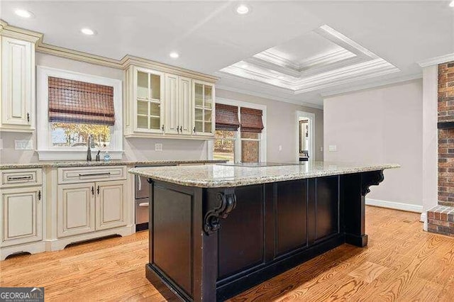 bar featuring cream cabinetry, light wood-type flooring, light stone counters, and ornamental molding