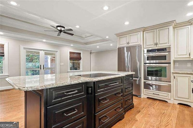 kitchen featuring cream cabinets, stainless steel appliances, light hardwood / wood-style flooring, and crown molding