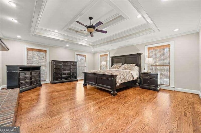 bedroom featuring ceiling fan, light hardwood / wood-style floors, ornamental molding, and a tray ceiling