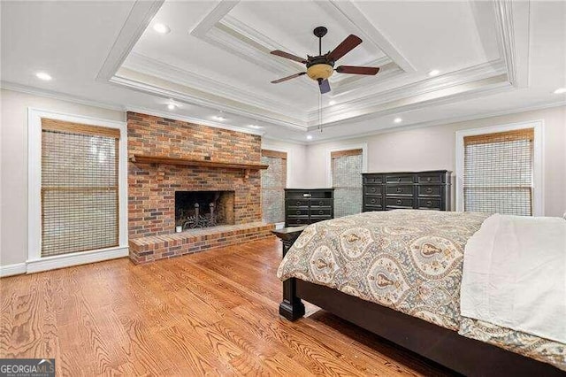 bedroom featuring a raised ceiling, ceiling fan, crown molding, and light hardwood / wood-style floors