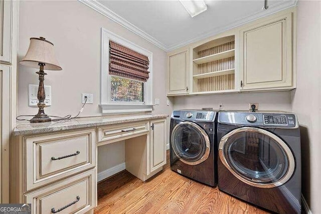 washroom featuring washing machine and clothes dryer, cabinets, light wood-type flooring, and ornamental molding