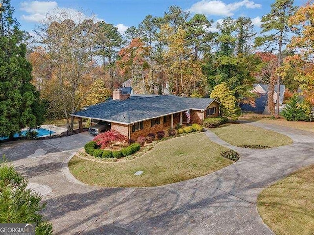 view of front of property featuring a front lawn and a carport