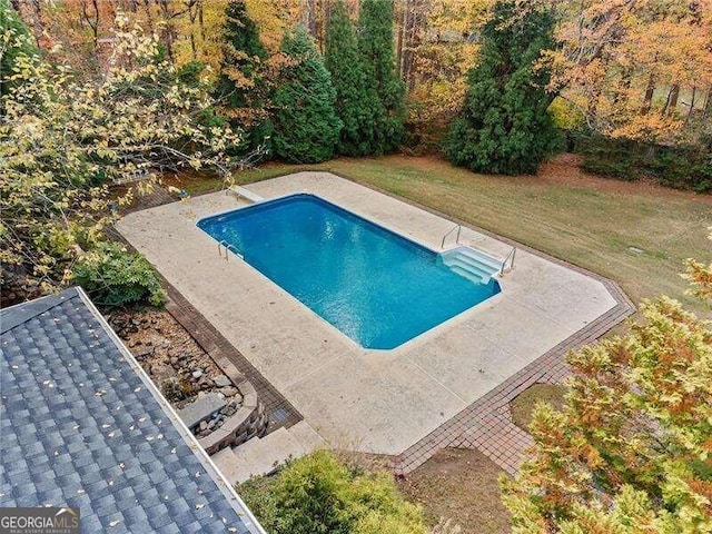 view of swimming pool featuring a yard