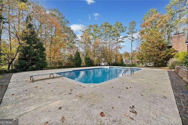 view of pool featuring a patio and a diving board