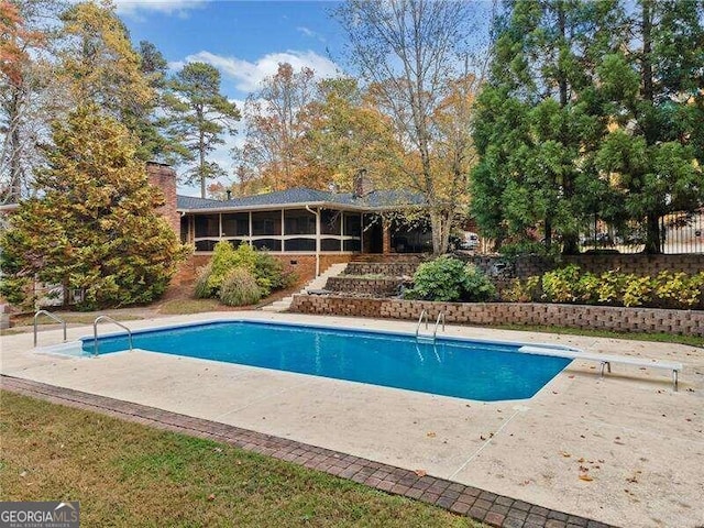 view of pool featuring a patio and a diving board