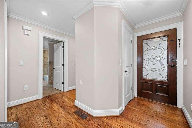 foyer entrance with light hardwood / wood-style floors and ornamental molding