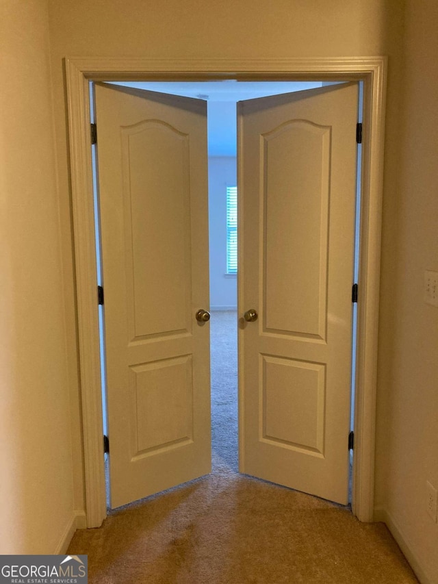 hallway featuring light carpet