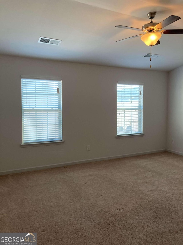 spare room featuring ceiling fan and carpet