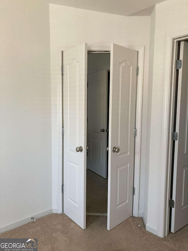 unfurnished bedroom featuring light carpet