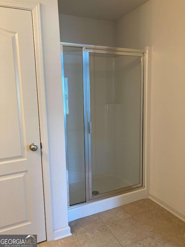 bathroom featuring tile patterned flooring and a shower with shower door