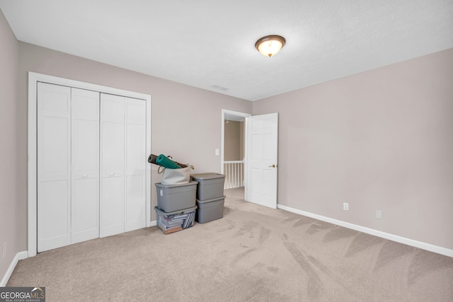 bedroom with light carpet and a closet