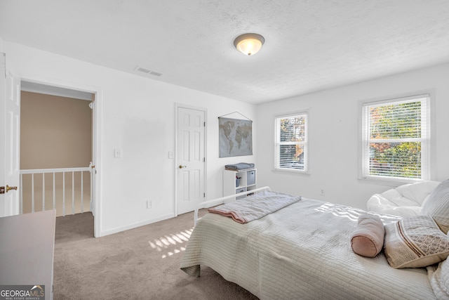 carpeted bedroom featuring a textured ceiling