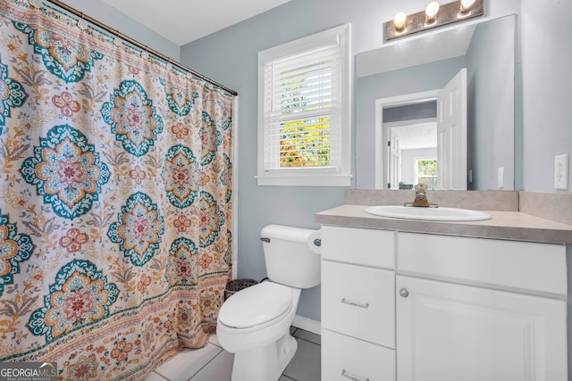 bathroom featuring tile patterned flooring, vanity, toilet, and walk in shower