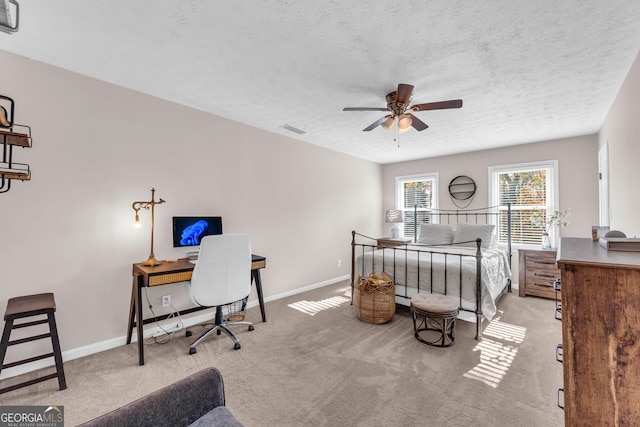 carpeted bedroom featuring a textured ceiling and ceiling fan