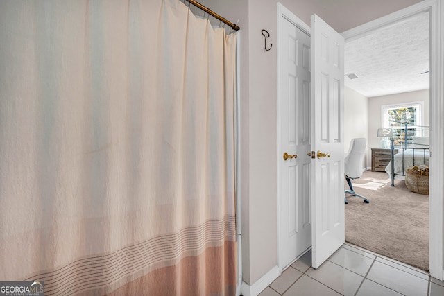 bathroom with tile patterned flooring and a textured ceiling