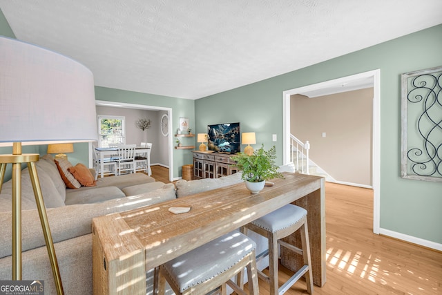 dining room with a textured ceiling and light hardwood / wood-style flooring