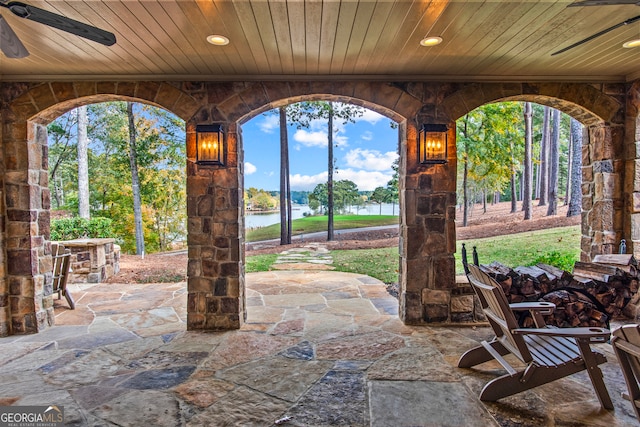 view of patio / terrace featuring ceiling fan and a water view