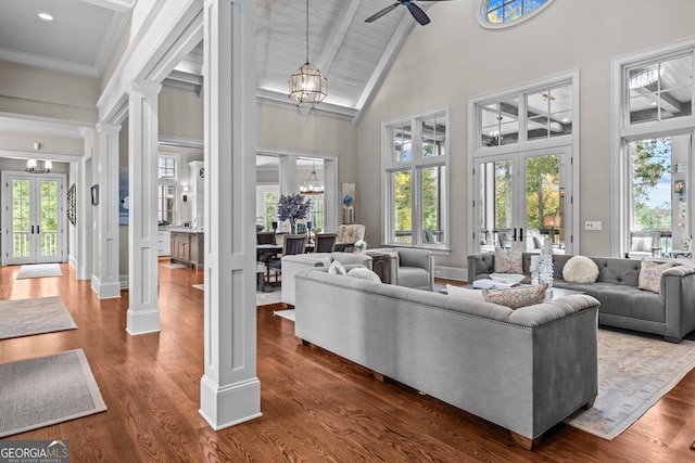 living room with ornate columns, french doors, high vaulted ceiling, and ceiling fan with notable chandelier