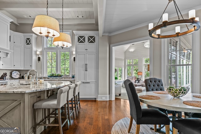 dining room featuring beam ceiling, sink, dark wood-type flooring, wood ceiling, and ornamental molding