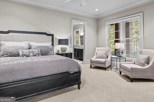 bedroom featuring ceiling fan, light colored carpet, crown molding, and ensuite bath