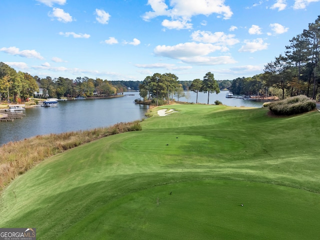 surrounding community with a water view and a yard