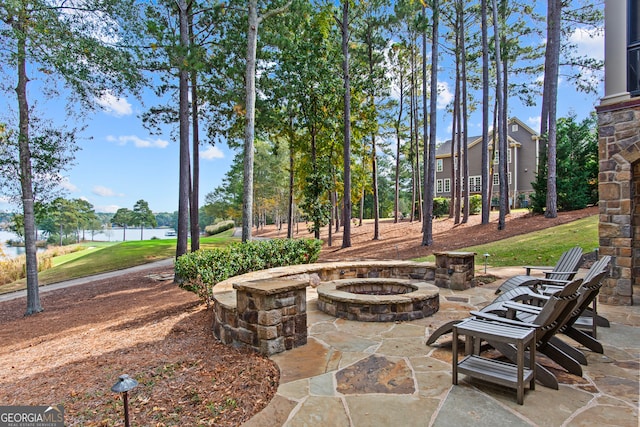 view of patio / terrace with a fire pit and a water view