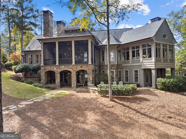 rear view of property featuring a sunroom