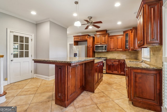 kitchen featuring light stone countertops, a center island, ornamental molding, and appliances with stainless steel finishes