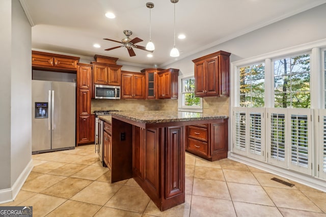 kitchen featuring crown molding, light stone counters, backsplash, and appliances with stainless steel finishes