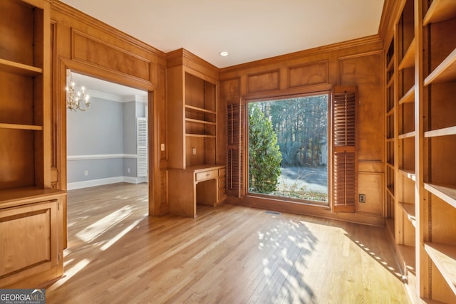 unfurnished office featuring ornamental molding, light hardwood / wood-style floors, and a notable chandelier