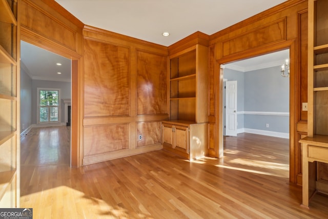 interior space with crown molding, light hardwood / wood-style floors, and a notable chandelier