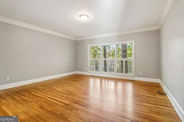 empty room with wood-type flooring and crown molding