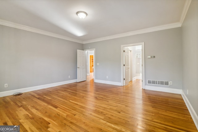 spare room with light hardwood / wood-style floors and crown molding