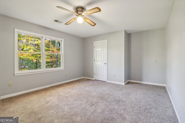 carpeted spare room featuring ceiling fan