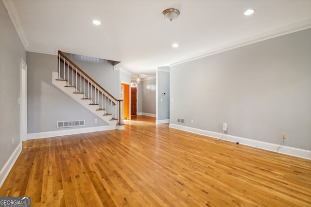 unfurnished living room featuring ornamental molding and light wood-type flooring