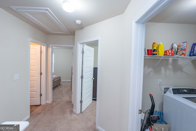 clothes washing area with light colored carpet and washer / dryer