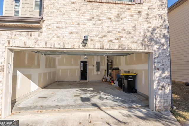 garage with strapped water heater and electric panel