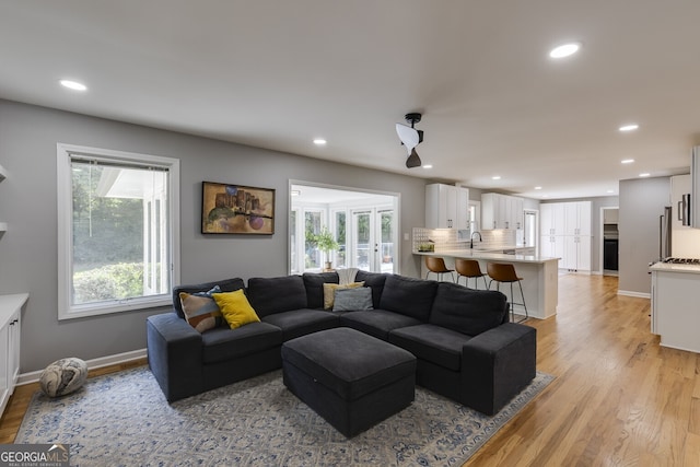 living room featuring light wood-type flooring and sink