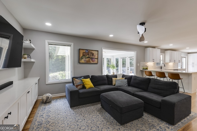 living room featuring light wood-type flooring and sink