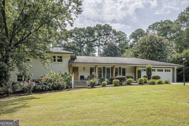 split level home with covered porch, a garage, and a front yard