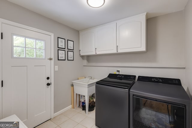 laundry room with separate washer and dryer, light tile patterned floors, and cabinets