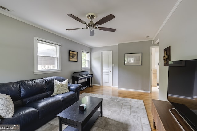 living room featuring ceiling fan, light wood-type flooring, and crown molding