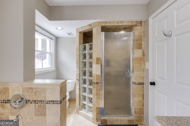 bathroom featuring tile patterned floors, toilet, and an enclosed shower