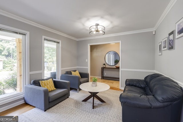 living room with light hardwood / wood-style flooring, a notable chandelier, and ornamental molding